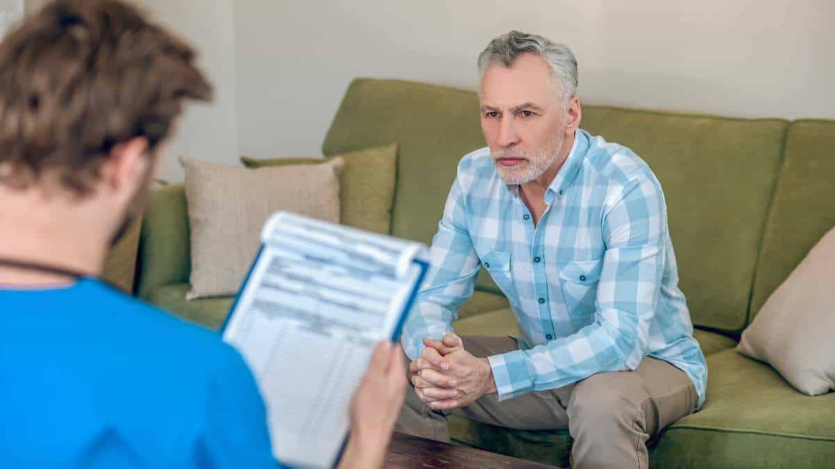 Therapist talking to male patient during medication-assisted treatment. 
