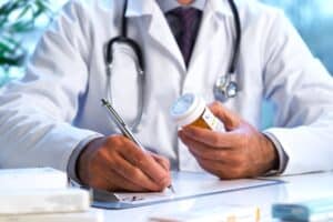 male doctor writing a prescription to help patient overcome meth detox