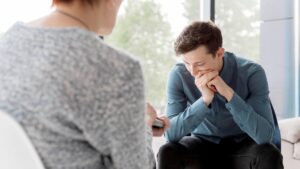 A man struggling with depression during detox talking to a therapist.