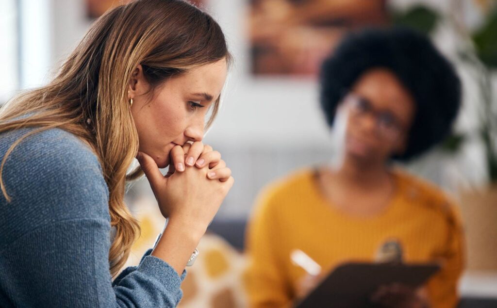 Woman receiving guidance from a therapist on when to seek inpatient mental health treatment.