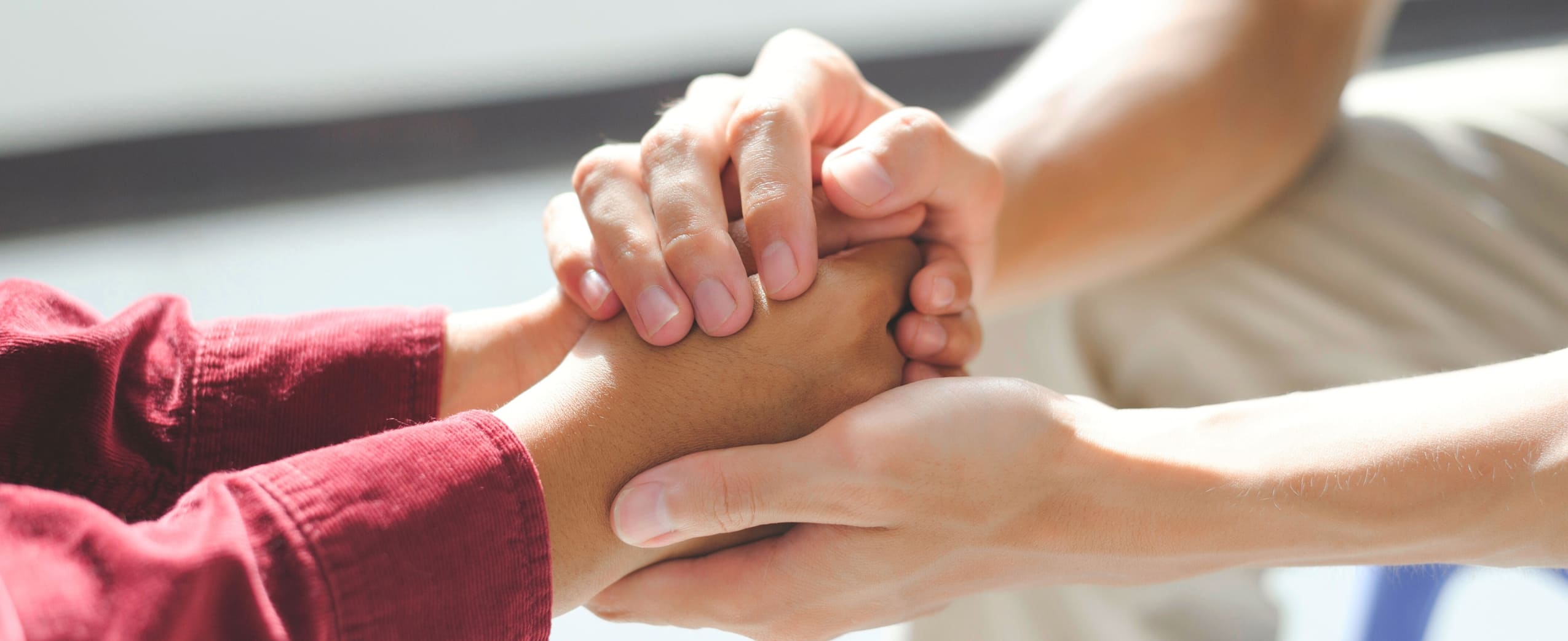 Therapist holding a client's hand during inpatient mental health treatment.